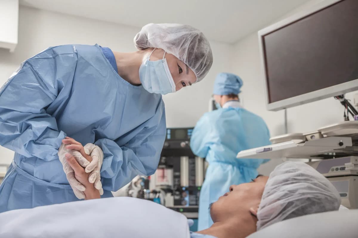 Surgeon preparing for surgery comfort patient in a modern operating room