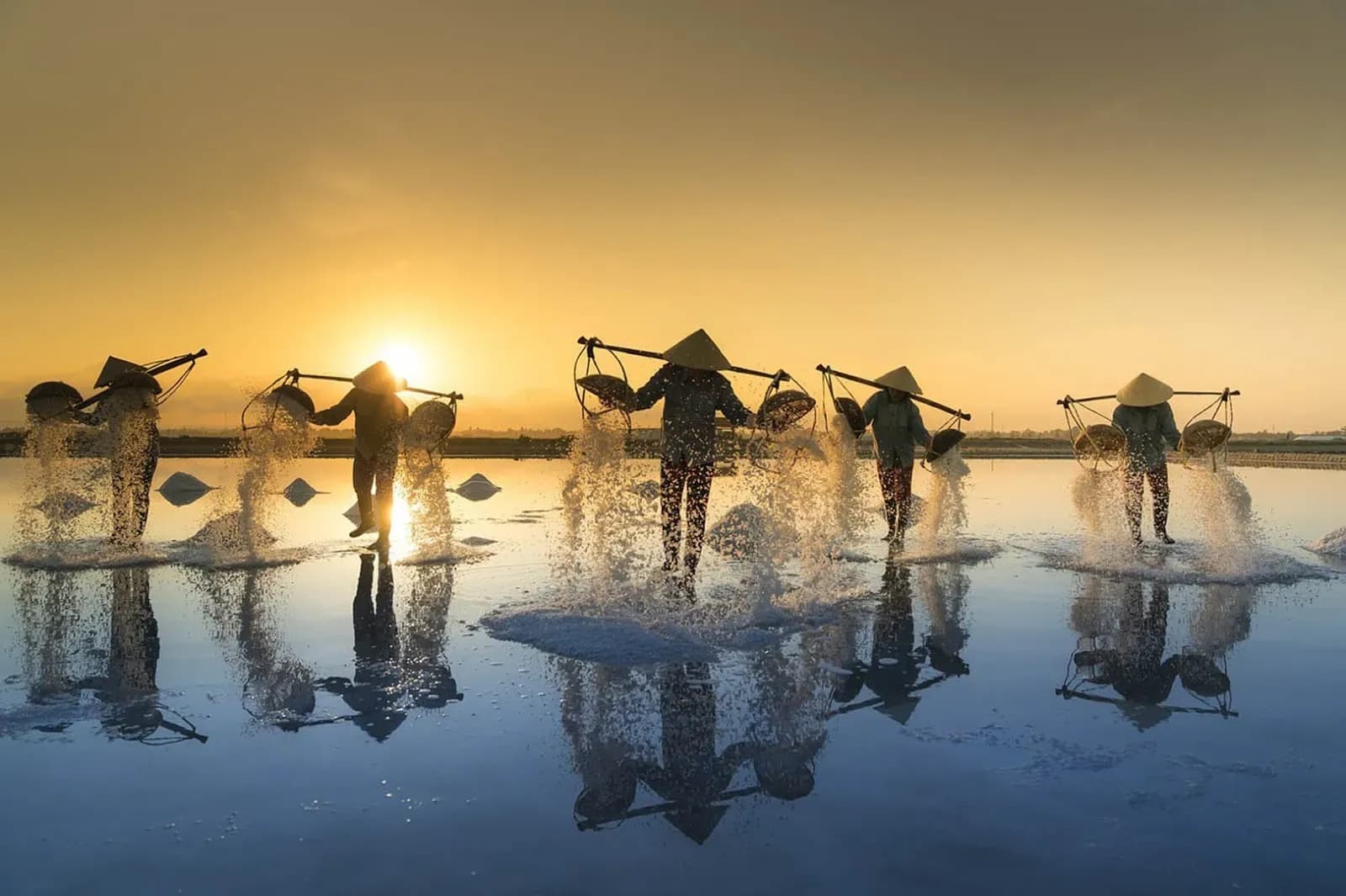 A salt dance under the sunset, with white grains gracefully tossed into the vibrant sky.