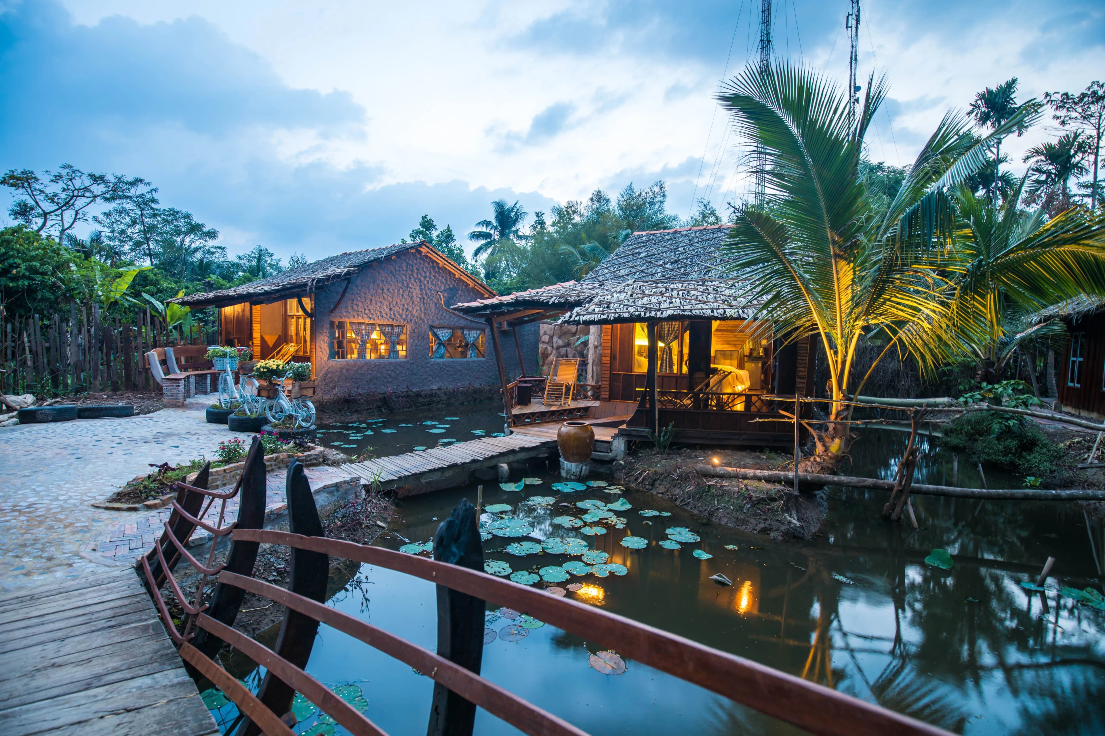 A wooden house on the canal side at Mekong Rustic, Can Tho, offering a peaceful space in harmony with nature.