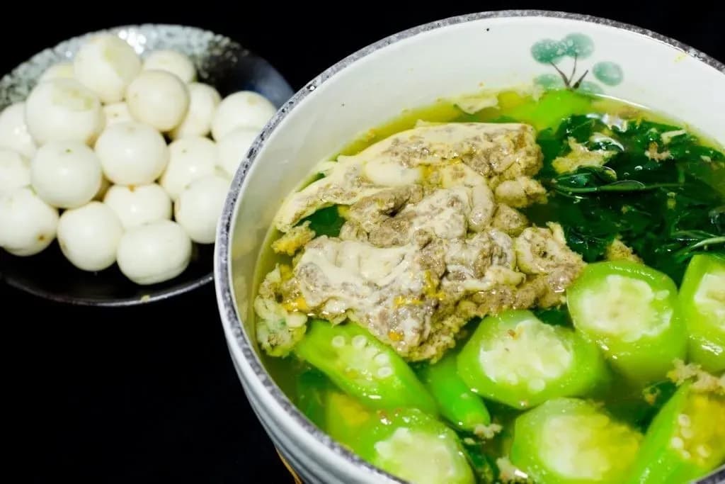 Crab soup with jute leaves and loofah, served with pickled eggplants.