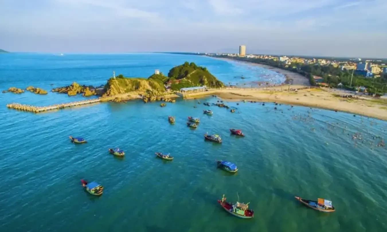 The stunning view of Cua Lo Beach with boats on the vibrant blue waters.
