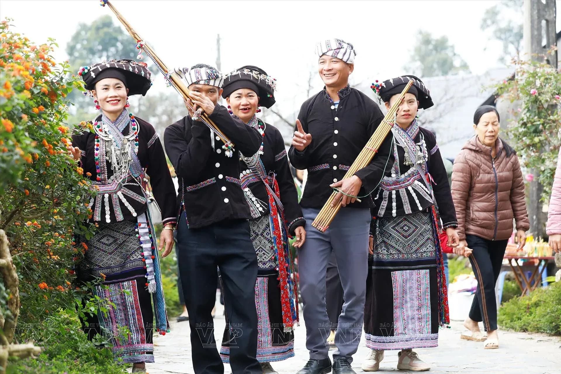 Lao group joyfully parading in a traditional festival with ethnic instruments.