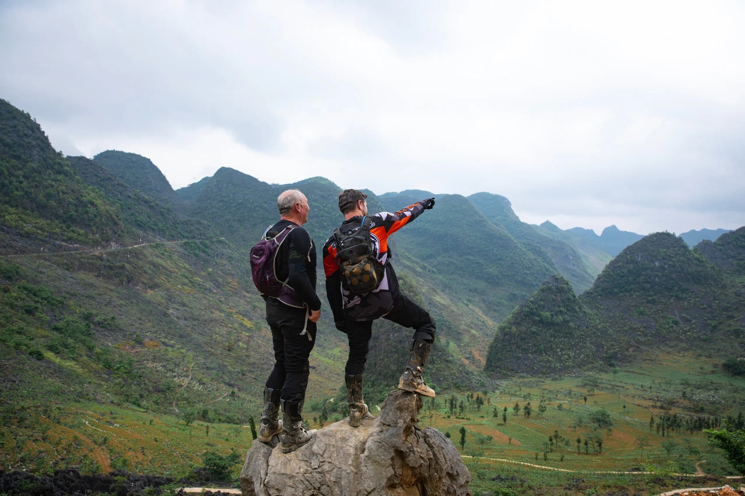 Two men are seen packing light luggage, carefully organizing their belongings into compact bags, ready for an adventure