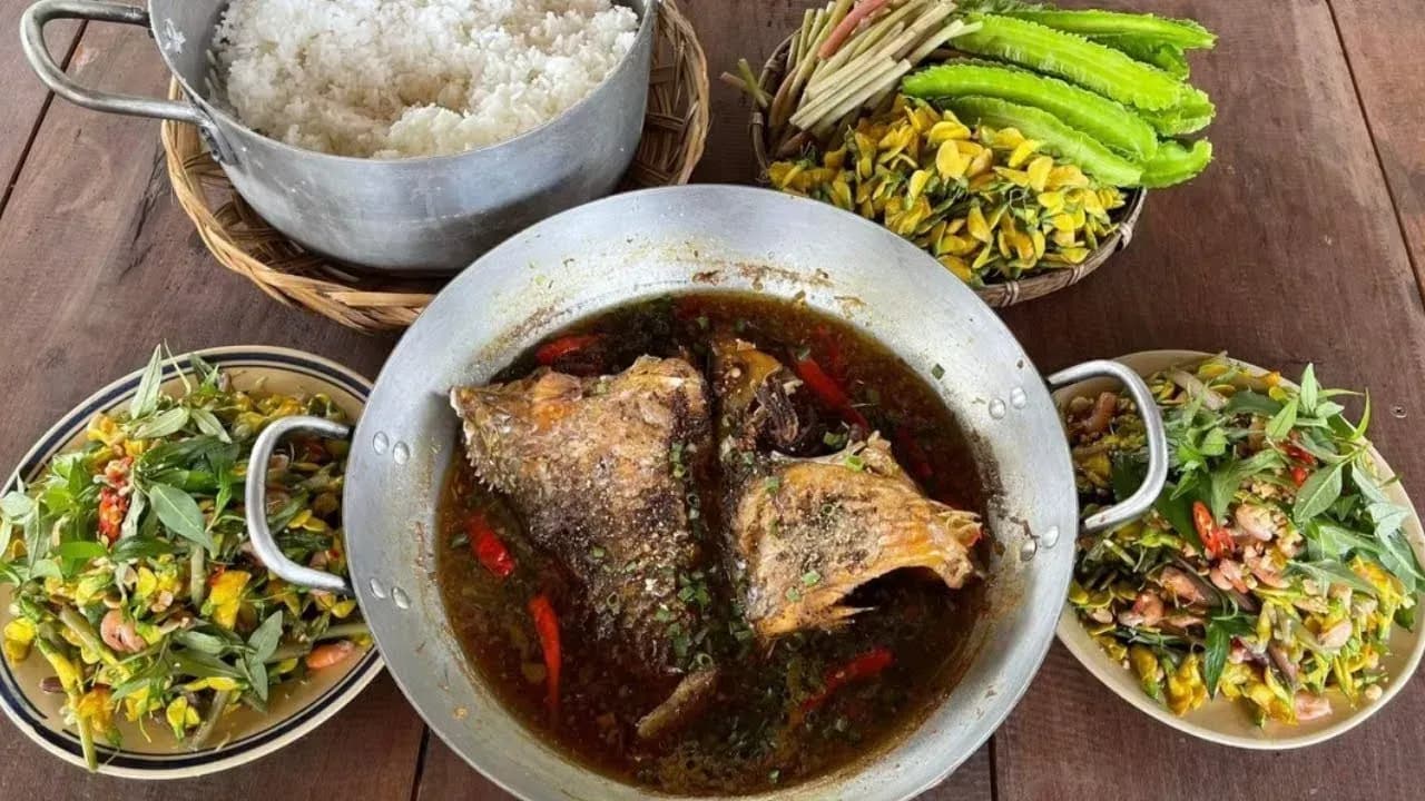 A savory dish of braised catfish with coconut water, served with rice and vegetables.