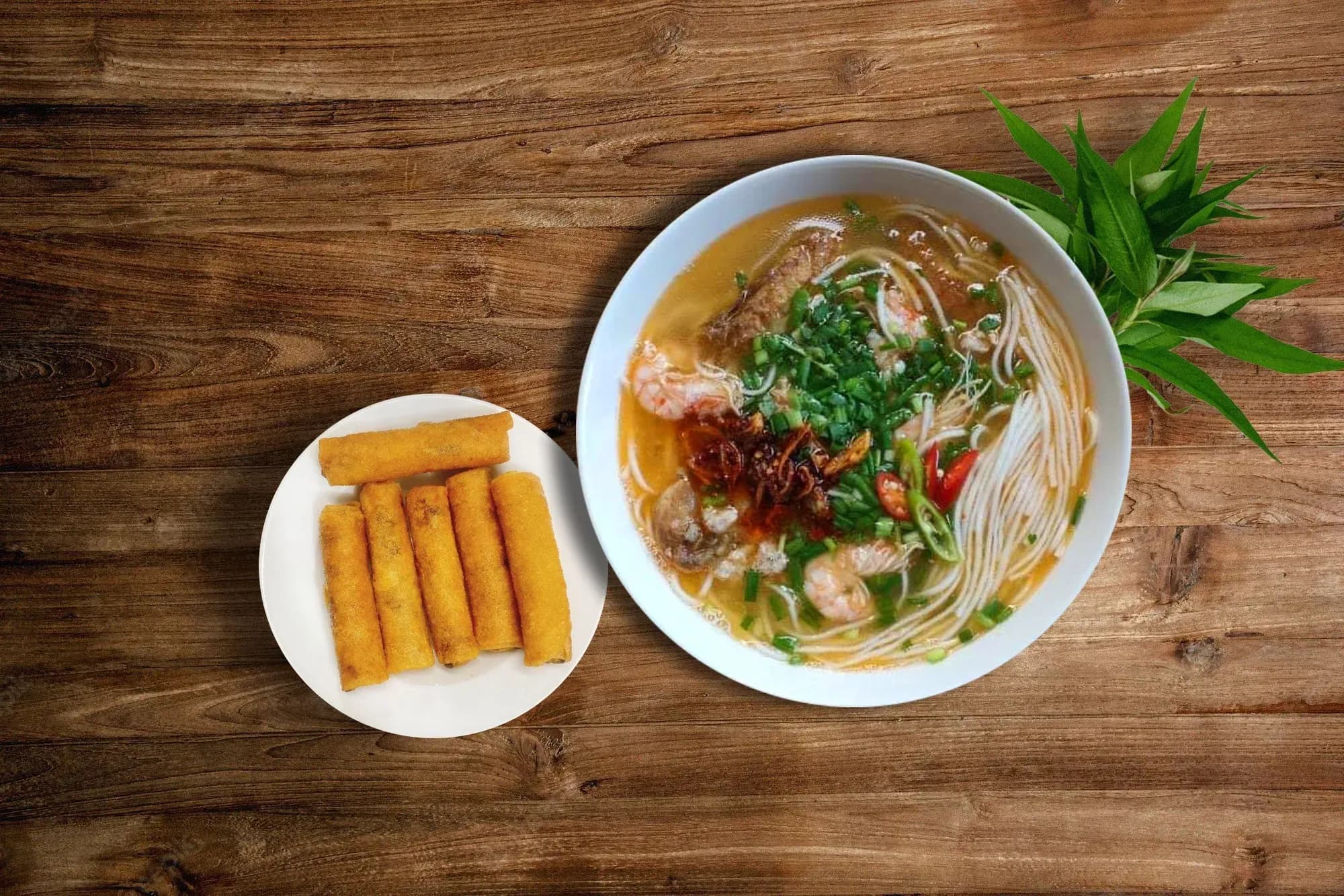A bowl of Quang Binh porridge and fried rolls on wooden background, exuding rustic culinary vibes.