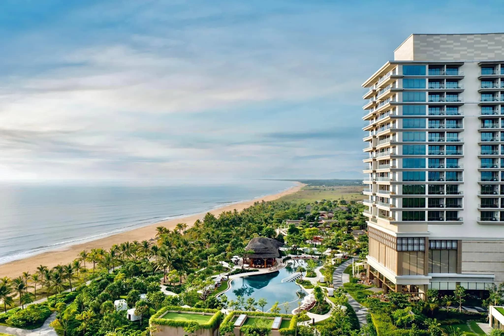 Luxurious coastal resort with a stunning pool and lush greenery.