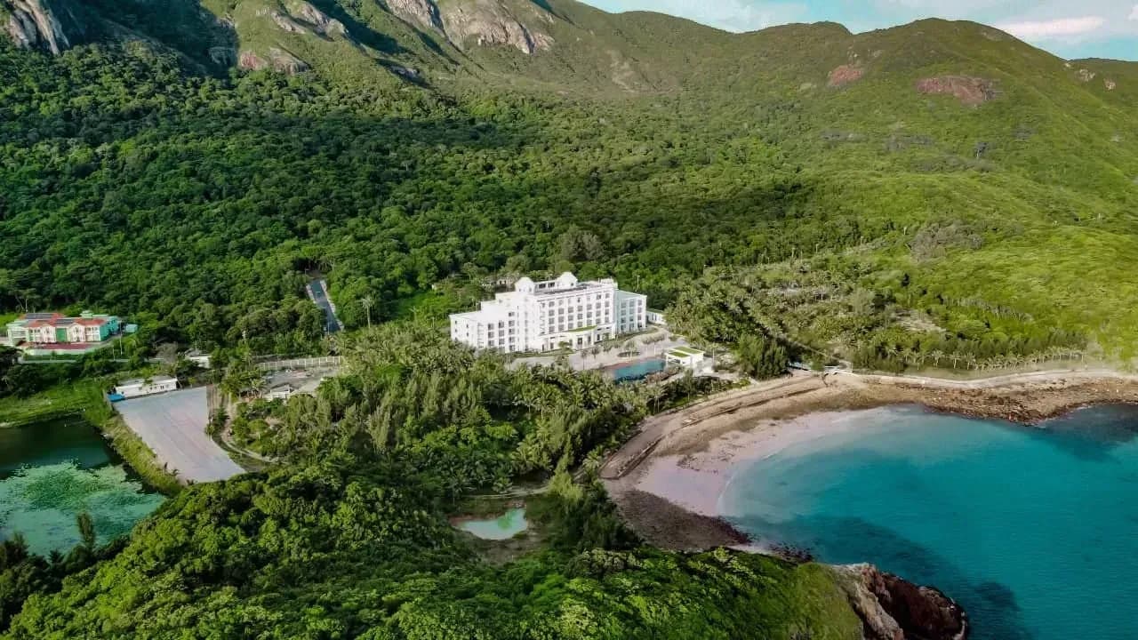 Aerial view of Orson Hotel & Resort Con Dao nestled in lush greenery and private beach.