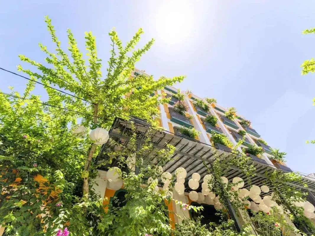 A lush building with numerous decorative lanterns, viewed from below.